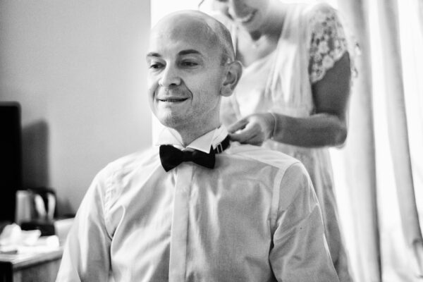 La sposa aiuta lo sposo ad indossare il papillon