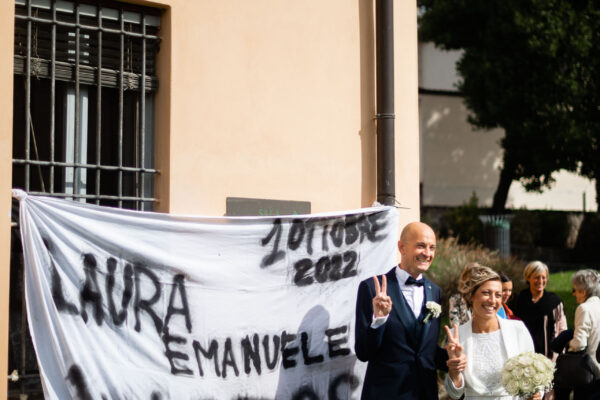 Gli sposi posano davanti ad uno striscione preparato dai loro amici