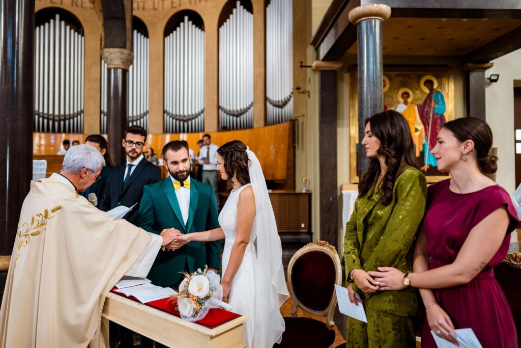 Valentina e Marco durante la benedizione degli sposi nella chiesa di San Vito a Milano, con le testimoni che si tengono per mano